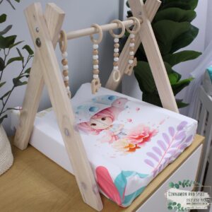 Neutral-toned changing mat cover with sage rainbow and sun motif—soft stretchy fabric for stylish and comfy diaper changes.