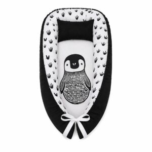 Monochrome Herringbone Penguin baby nest with padded raised sides and a small matching head pillow, designed to create a cozy, secure sleeping space for infants.
