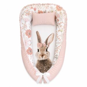 Peachy Vol In Blom Bunny baby nest with padded raised sides and a small matching head pillow, designed to create a cozy, secure sleeping space for infants.