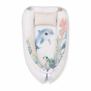 Dolphin Under The Sea baby nest with padded raised sides and a small matching head pillow, designed to create a cozy, secure sleeping space for infants.