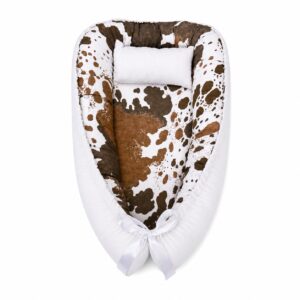 Southwest Icons baby nest with padded raised sides and a small matching head pillow, designed to create a cozy, secure sleeping space for infants.