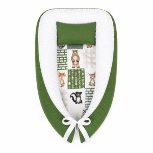 Green Patchwork Woodlands baby nest with padded raised sides and a small matching head pillow, designed to create a cozy, secure sleeping space for infants.