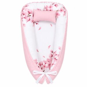 Cherry Blossom Pink Flower baby nest with padded raised sides and a small matching head pillow, designed to create a cozy, secure sleeping space for infants.