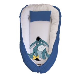 Eeyore Blue Oldie baby nest with padded raised sides and a small matching head pillow, designed to create a cozy, secure sleeping space for infants.