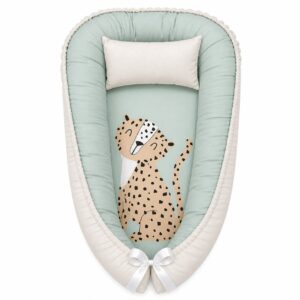 Dotty Spotty Cheetah Safari baby nest with padded raised sides and a small matching head pillow, designed to create a cozy, secure sleeping space for infants.