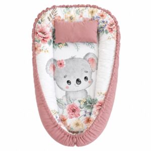 Koala Dusty Pink Love baby nest with padded raised sides and a small matching head pillow, designed to create a cozy, secure sleeping space for infants.