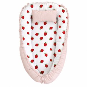 Strawberries and Pink baby nest with padded raised sides and a small matching head pillow, designed to create a cozy, secure sleeping space for infants.
