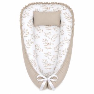 Wildflower Twirling Bunny baby nest with padded raised sides and a small matching head pillow, designed to create a cozy, secure sleeping space for infants.