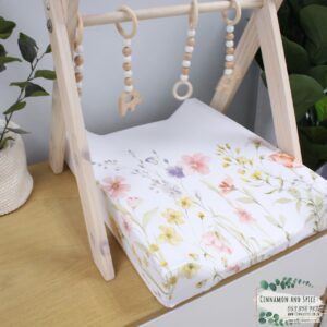 Neutral-toned changing mat cover with sage rainbow and sun motif—soft stretchy fabric for stylish and comfy diaper changes.