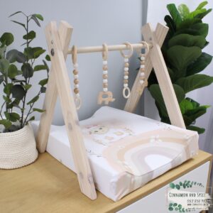 Neutral-toned changing mat cover with sage rainbow and sun motif—soft stretchy fabric for stylish and comfy diaper changes.