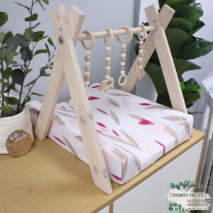 Neutral-toned changing mat cover with sage rainbow and sun motif—soft stretchy fabric for stylish and comfy diaper changes.