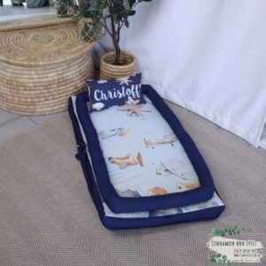 Printed baby nest / baby pod with matching pillow in Blue Sky Adventure Planes tones, offering a cozy, secure space for newborns – part of a handcrafted South African nursery set. Cinnamon and Spice