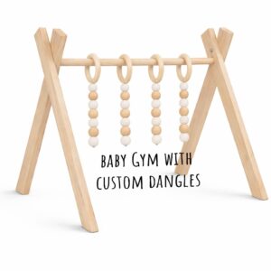 Minimalist Black wooden baby gym with hanging wooden toys on white background