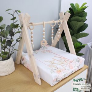 Neutral-toned changing mat cover with sage rainbow and sun motif—soft stretchy fabric for stylish and comfy diaper changes.