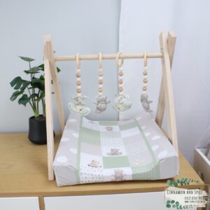 Neutral-toned changing mat cover with sage rainbow and sun motif—soft stretchy fabric for stylish and comfy diaper changes.