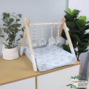 Neutral-toned changing mat cover with sage rainbow and sun motif—soft stretchy fabric for stylish and comfy diaper changes.