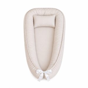 Beige Light baby nest with padded raised sides and a small matching head pillow, designed to create a cozy, secure sleeping space for infants.