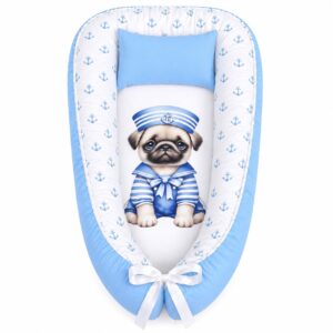 Blue Who Let The Pugs Out At Sea baby nest with padded raised sides and a small matching head pillow, designed to create a cozy, secure sleeping space for infants.