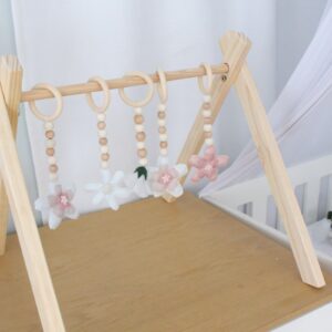 Natural wooden baby gym with minimalist wooden dangles hanging from frame. Brand: Cinnamon and Spice