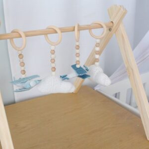 Natural wooden baby gym with minimalist wooden dangles hanging from frame. Brand: Cinnamon and Spice