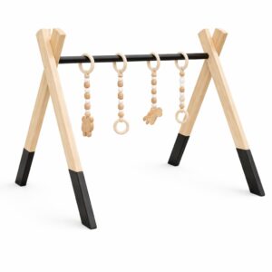 Minimalist natural wooden baby gym with hanging wooden toys on white background