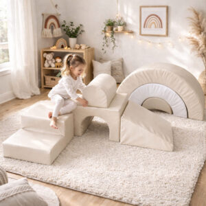 Toddler playing on beige PVC soft play foam climbing set in a modern neutral nursery with rainbow décor.