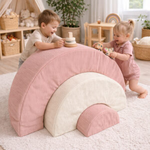 Little girl and boy playing on beige and pink soft play rainbow set in modern cosy playroom in South Africa