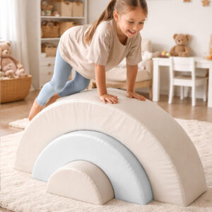 Little girl playing on beige and white soft play rainbow set in modern cosy playroom in South Africa